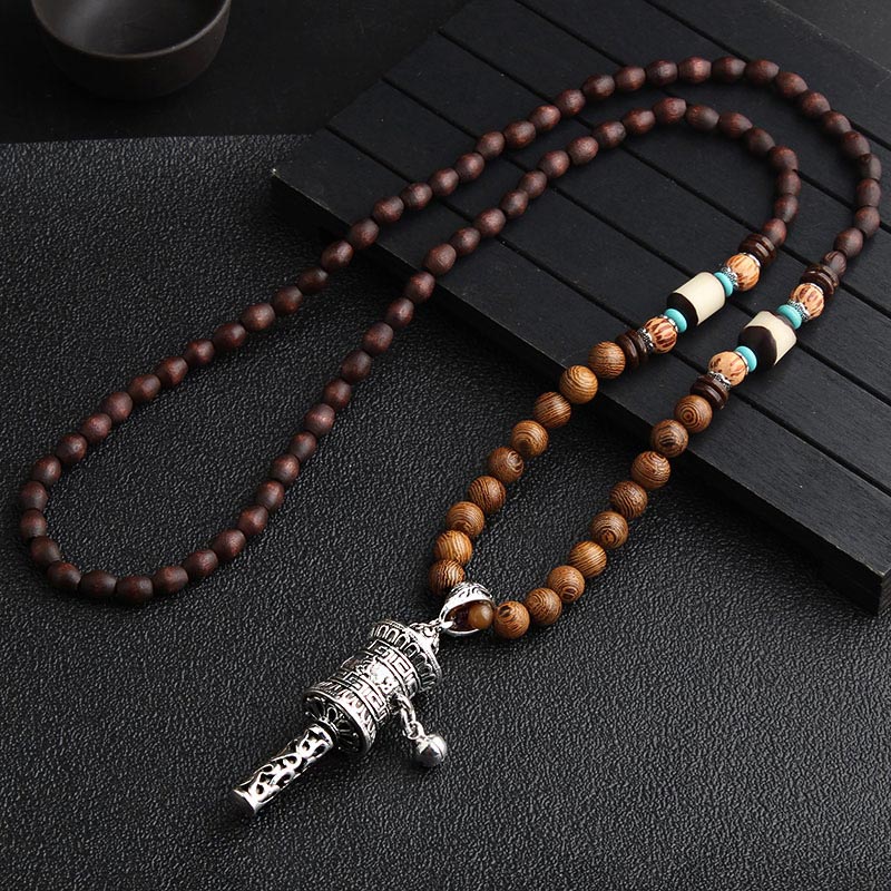 Wooden beaded necklace with a silver pendant on a dark surface